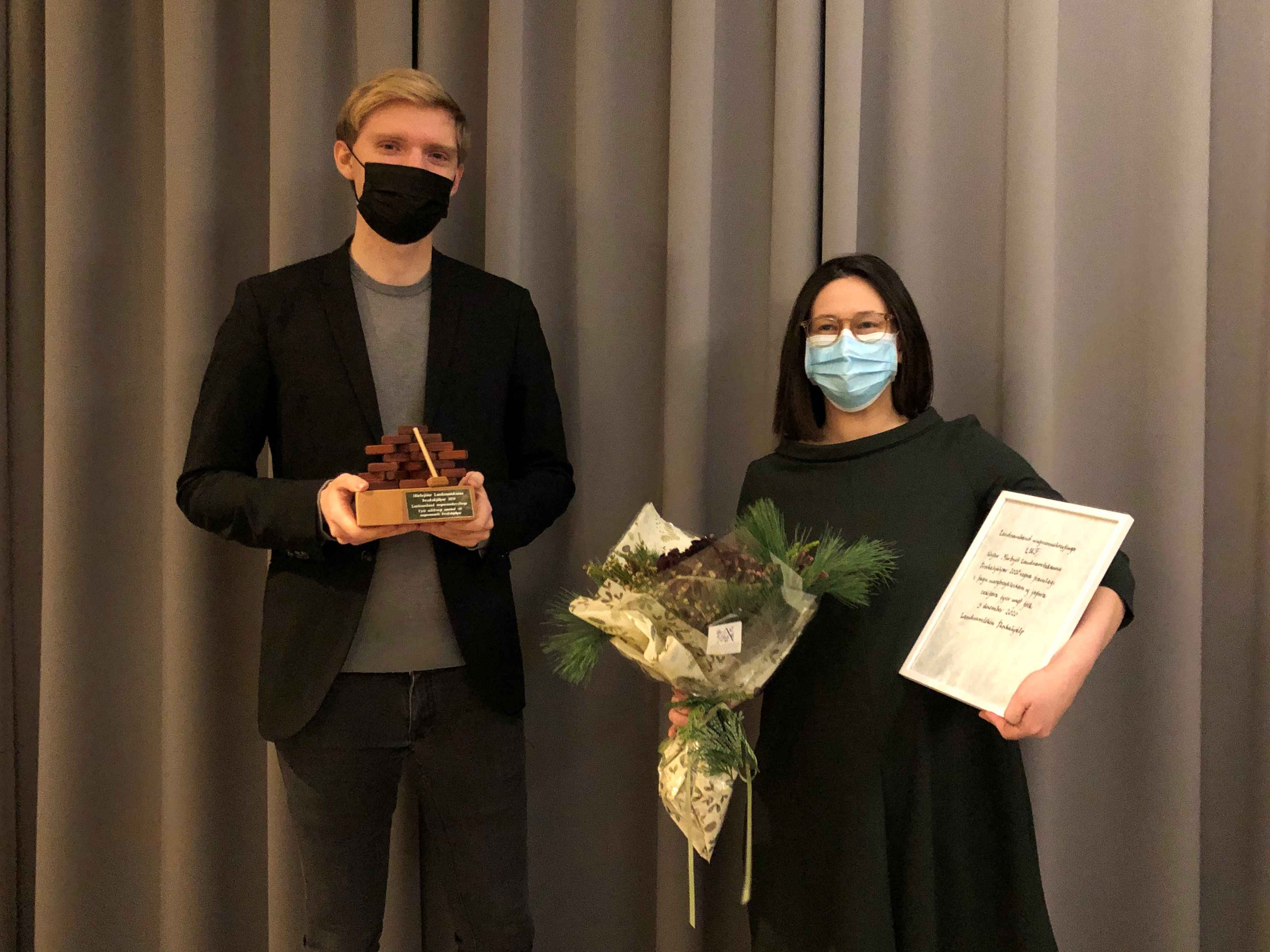 Geir Finnsson og Tinna Isebarn, fulltrúar LUF Ungur maður og ung kona halda á verðlaunagrip, blómvendi og viðurkenningarskjali.